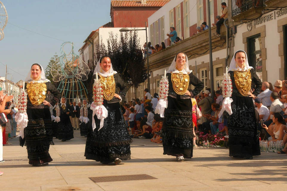 Four women in traditional dress participating in a parade